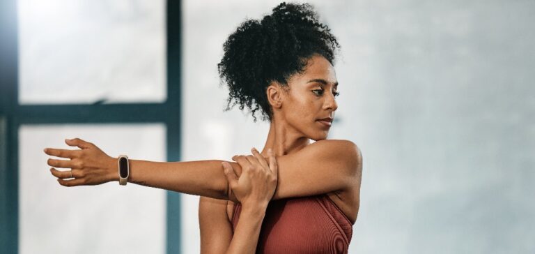 Fitness, schwarze Frau oder Mädchen im Fitnessstudio streckt die Arme, um den Körper aufzuwärmen oder die Muskeln für das Training zu entspannen. Wellness, Fokus oder gesunder Sportler, der bereit ist, mit dem Training zu beginnen oder zu trainieren, in Atlanta